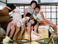 A shot from Kuei-­mei, a Woman, showing a tired-­out mother with four sleeping children in their flooded home.