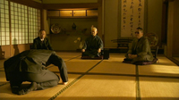 Man bowing in a room in front of elders