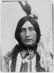 A portrait of Óta Kté, in English, Luther Standing Bear, the Lakota author, educator, philosopher, and actor. He wears traditional Lakota dress.