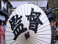 person opening up an umbrella which has calligraphy on it
