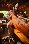 A color photograph of Erik Simula working on a birch-bark canoe.