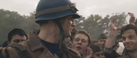 Steve surrounded by cheering soldiers, with Bucky barely visible