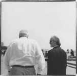 Two men walking together, photo taken from behind