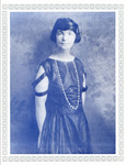 Sanger posed in a three-quarter view in a silky gown with a scooped neck, short sleeves, and long beads. Her mid-length hair is pulled back with a barrette. Silver border with lanterns.