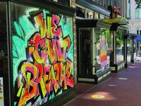 Storefront of restaurant Oyamel in Washington, DC, glass spray painted in graffiti, bubble letters, "I Can't Breathe," in a style from the early days of hip hop graffiti in the late 1970s and early 1980s.