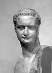 Portrait of emperor Domitian with his beardless head turned to its left. Mouth closed, deep-lying eyes fixed on the far distance. Hair cropped short and curled. Long neck on bare breast.
