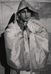 Figure 5.2. Park Yeong-in stands with hands palms together in front of his chest, eyes open. He wears a peaked hat and a white robe with wide sleeves that drape in front of his chest.