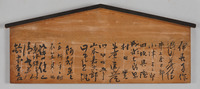 A wooden board, with angled black trim on top, with several vertical columns of calligraphic signatures.
