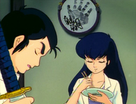 A framed handprint from a sumo wrestler, who signed it by brush, adorns the wall of a restaurant above two characters in this animated film.