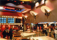 A spacious movie theatre lobby with many people and movie posters.