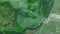Aerial view of Marshej, with houses to the east and west and vegetation in center.