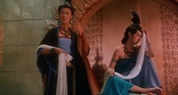 One woman faces offscreen and another looks away, dressed formally. Calligraphy can be seen in the mirror behind them.