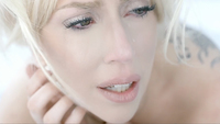 Figure 22. Lady Gaga, seen in extreme close-up, appears as a pale, distressed blonde woman with tears on her cheeks looking off to her left.