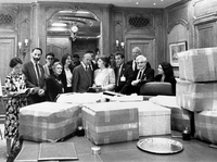 People standing behind a table covered with boxes.