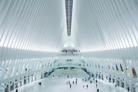 Light pours into a building featuring a vast concourse, elliptical dome, steel ribs, and a marble floor.