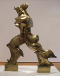 A photograph of a three-­and-­a-­half foot tall brass statue that depicts a human figure in a conquistador hat striding forward with great energy. The vigorous movement of the figure is suggested via rippling metal waves that radiate backwards from the figure’s legs, back, buttocks, and shoulders. As with much classical statuary, the figure’s arms are truncated just past the shoulders.