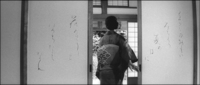 Protagonist Oriko moves in the center of the frame from the foreground into the midground, through an opening in the fusama sliding doors. She wrote the poem in delicate cursive calligraphy.