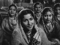 Medium shot of Anarkali (Madhubala) singing the qawwali “Teri Mehfil Mein” in Mughal-­e-­Azam. Her gaze and gesture are directed just above the camera, at Prince Salim (offscreen). Seated behind her are four women backup singers, smiling at her.