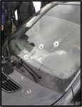Black Mercedes that belonged to Farayd. Bullet holes riddle the front window and hood of the car. This was the car that Farayd and Sobir were shot in on May 21, 2014.