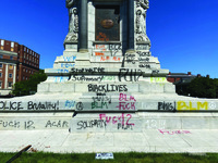 Image is a photo of the base of a Confederate Statue which has been graffitied with anti-racist slogans, such as "Black Lives Matter" and "End White Supremacy."