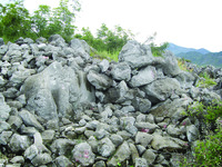 Remains of the stone wall at Kullaj, a large pile of stone rubble in the foreground.
