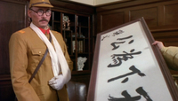 A Japanese general examines some decoration in a captured government office. He remarks, "Nice Calligraphy."