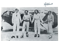 Four aviators stand in front of a small plane holding hands, posed for a news photo, smiling. All wear roller skates and jumpsuits except Gillies, who wears a long skirt.