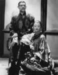 Photograph of Boris Karloff and Myrna Loy, both wearing prosthetic eye makeup and traditional Chinese-­looking robes