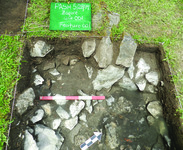 Plan-view photograph of Zagorë Unit 001, Feature 001. It contains rocks and dirt.