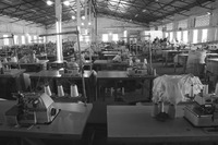 Fig05_01. A Kano textile mill with rows of tables with sewing machines, thread, and cloth.