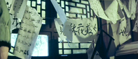 Image of several white pieces of paper with black calligraphy hanging on clotheslines near windows.