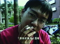 A shot from Boys for Beauty showing a teenage boy in red T-­shirt smoking in close-­up.