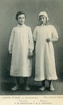 Photograph of Tyltyl (Khaliutina, left) and Mytyl (Koonen, right), holding hands, shoeless, dressed in stockings and three-quarter-length white nightgowns.