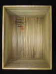 Photograph of a wooden box interior with black calligraphy and red seal.