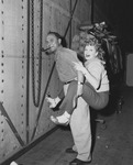 Man on a television stage with Lucille Ball straddling his back