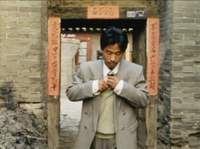 A man in a suit passes through a doorway framed by calligraphy.