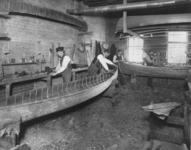 Sawdust litters the floor of the workshop at the Canadian Canoe Company factory as builders fashion canoes in distinctive shapes.