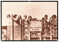 Women strikers, ethnic mix, in truck look toward viewer. Sign on truck reads “THE GOVERNOR SENDS 'AID' TO PIXLEY: 24 DEPUTY SHERIFFS, 11 HIGHWAY PATROLMEN. WE WANT FOOD!”