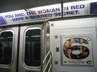A photo of an advertisement on a New York City subway train that says in capital purple letters "You and the woman in red have a shared secret." Beneath those words is the website "u-r-connected.com." Another ad on the subway features the tag line "Everyone is Connected. From JJ Abrams, Producer of Lost"  with a graphic of 6 degrees beneath that includes images of 6 actors. Below are the words "Six Degrees. Premieres Thursday September 21 10PM. ABC 7."