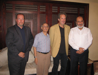 Figure 5. Four white men of varying heights stand in front of a mosaic backdrop and sofa in a Cairo hotel lobby.