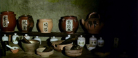 Image of a shelf of pottery, each piece labeled in black calligraphy.