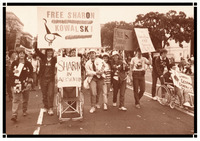 Lesbians in March on Washington. Signs read, “FREE SHARON KOWALSKI” and “Support Lesbian Disability Rights.” Some push an empty wheelchair with the sign “Sharon in Absentia.”