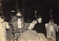 Black and white photograph, Manchu armors on display, Chiang Kai-­shek grins and lifts one belonging to Qianlong Emperor