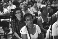 Photograph of a Codespa member sitting in the audience during a meeting.