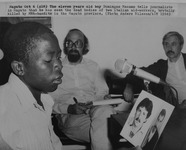 Fig. 58. An example of photographs taken at AIM, showing a young boy looking at headshots of two Italian aid workers who were killed in Renamo attacks.