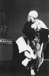 Figure 3.1. Wu, dressed as a Buddhist monk, puts two palms together in a praying gesture, raises his right foot slightly forward, and turns his head toward the wall at the left.