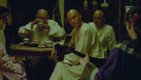A shot from Three Times showing a man at a feast dining and watching a geisha sing.
