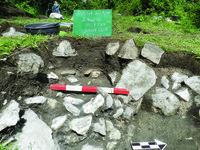 Profile-view photograph of Zagorë Unit 001, Feature 001. It contains a rock-lined pit.