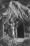 Fig. 59. An example of photographs taken at AIM, showing a woman carrying a baby on her back in front of a thatched house located in Mozambique’s countryside.