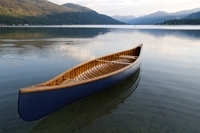 A photograph of a restored Chestnut Canoe in the water.